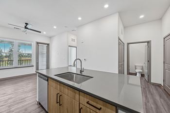 A modern kitchen with a large island and a fan.